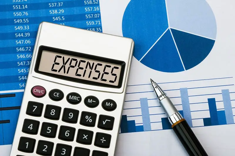 Keeping Track of Business Expenses - calculator, pen and expenses sheet