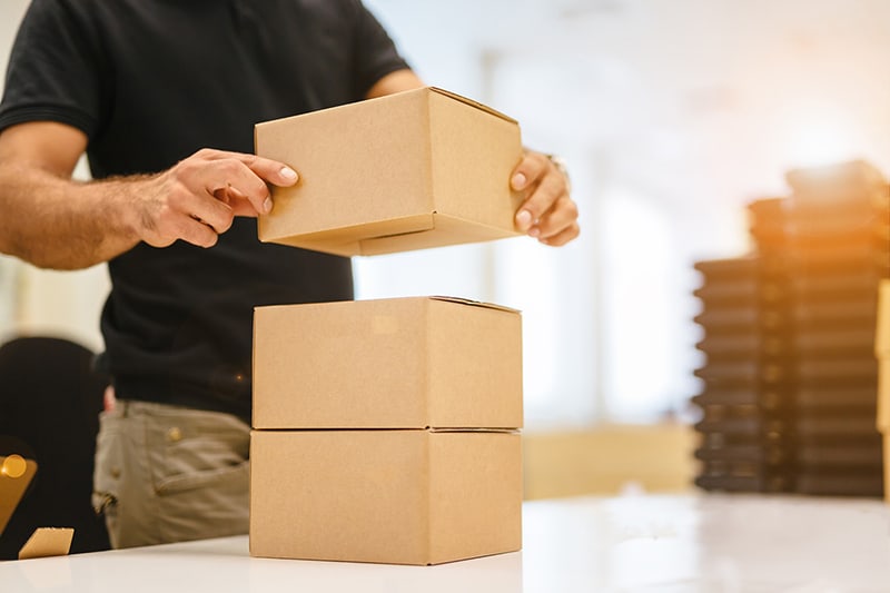 Person stacking boxed goods on a table