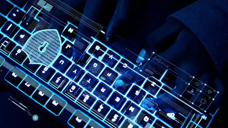 Closeup of hands using a keyboard – cyber security cyber crime - white collar crime
