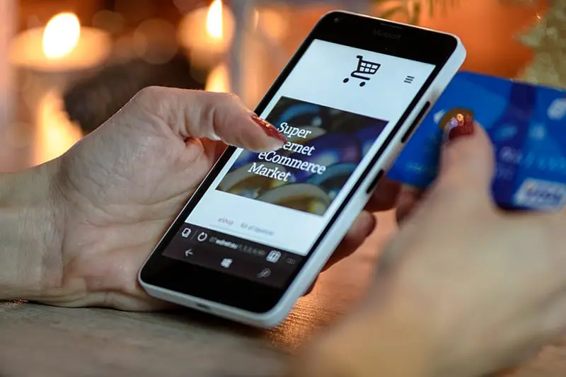 Person holding smartphone about to make a purchase from online store - ecommerce store