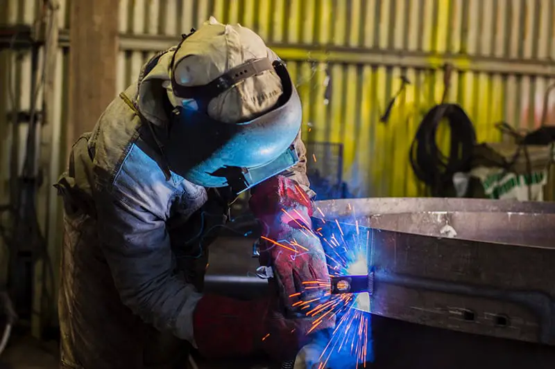 Man with safety gear doing welding and fabrication of the metal.