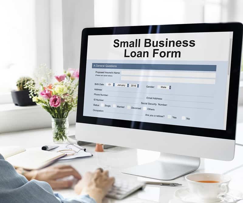 Person completing an application form for a Small Business Loan online