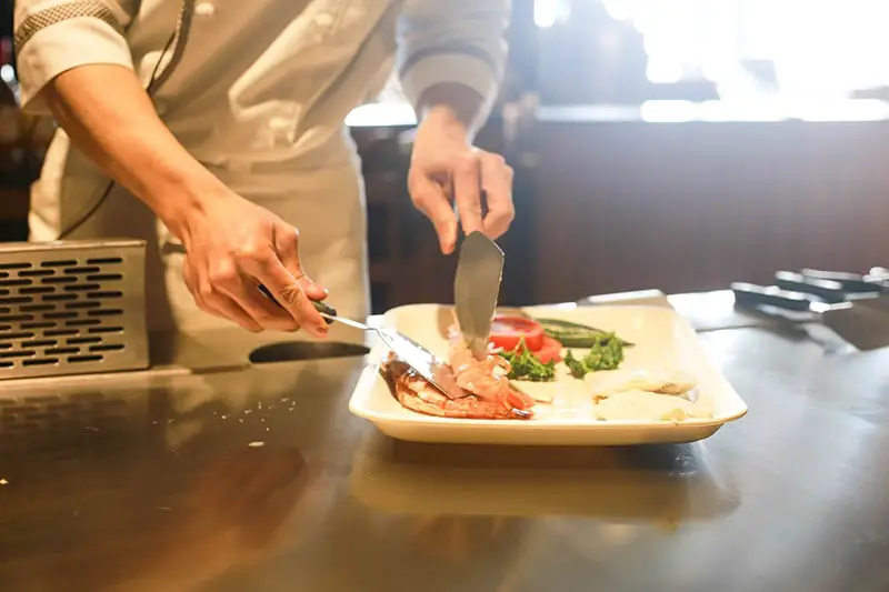 Restaurant chef plating up food for service