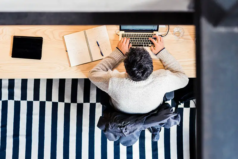 man sitting at a desk using laptop computer