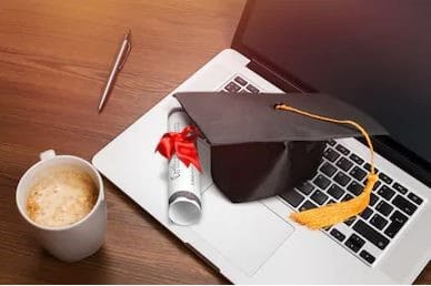 Academy graduation certificate and mortarboard on laptop