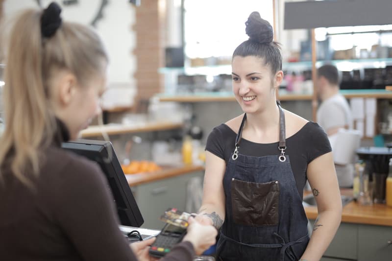 woman paying for goods and service with credit card