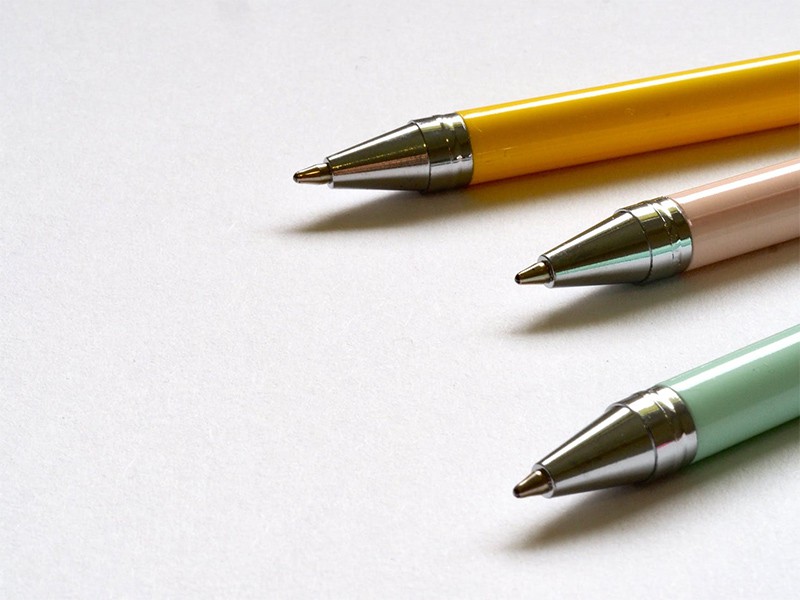 Three pens in yellow, pink and green colors.