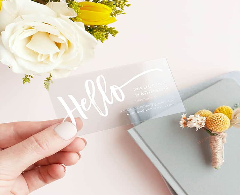 A hand of a woman holding a transparent business card