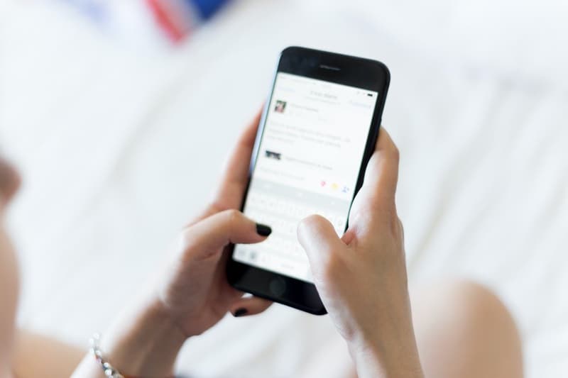 A hand of woman typing on mobile phone keyboard