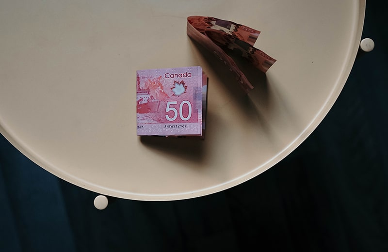 Several 50 Canadian dollar banknotes on a round table