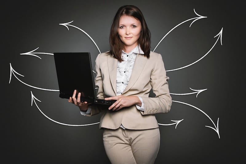 Woman in suit holding laptop
