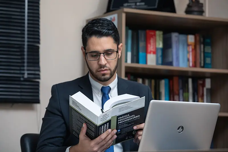 A lawyer with eyeglasses reading a book