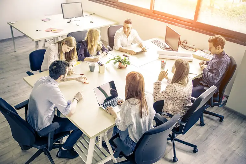 Group of people sitting around a table having a meeting.