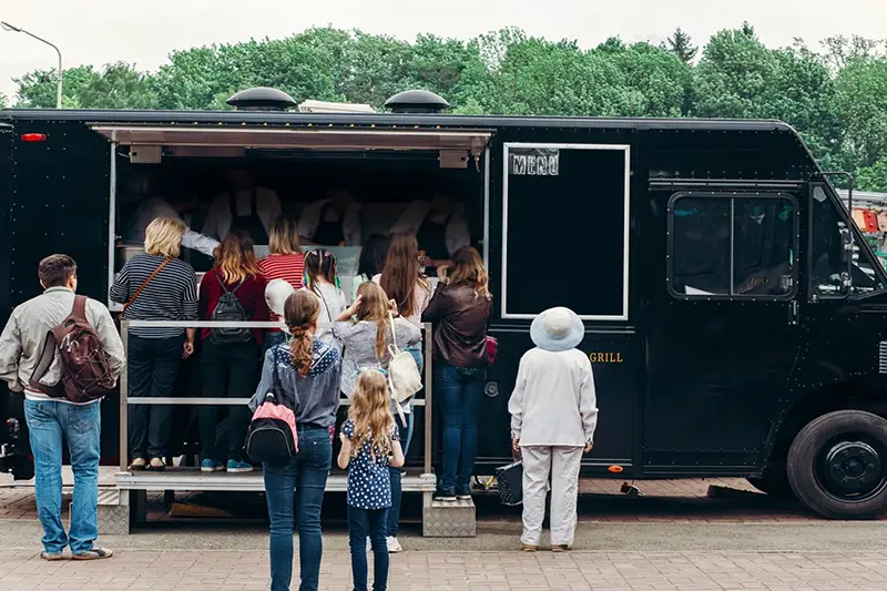 People standing in a queue at a food truck