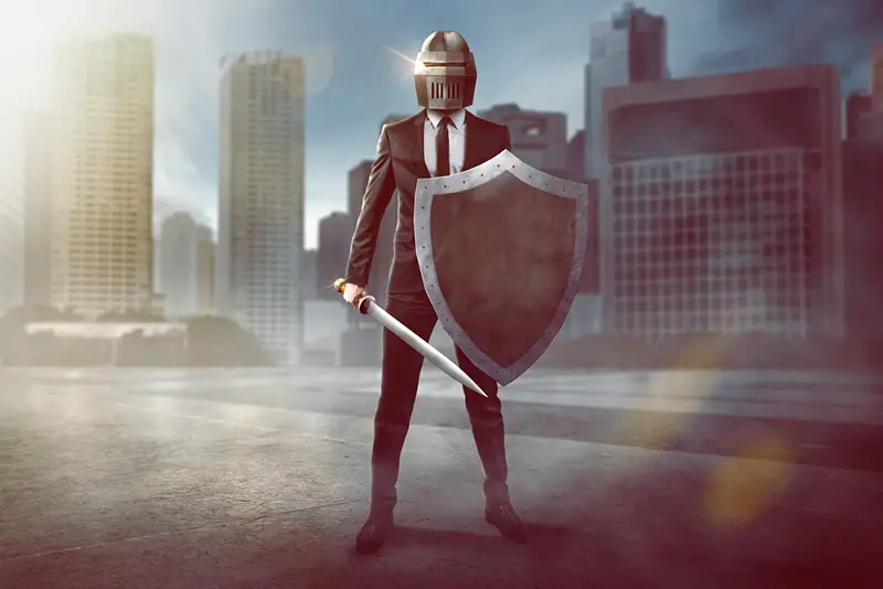 Business man in suit prepared for unexpected risk with sword, shield and helmet