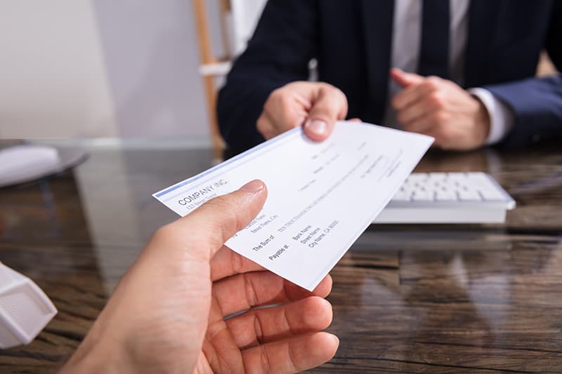 A businessman giving check to another person