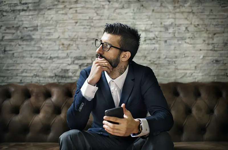 Victim of investment fraud - man in suit sitting on sofa