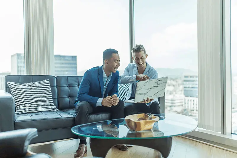 Two men on suit sitting in the couch