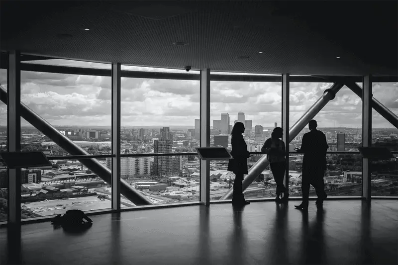 People having a marketing meeting looking out over city landscape