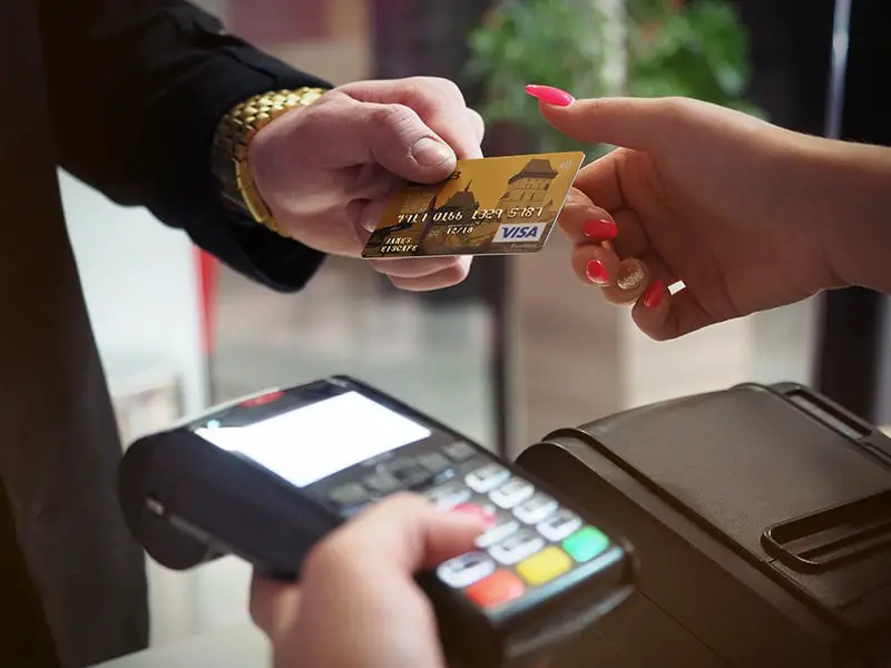 A man handing the credit card to a woman