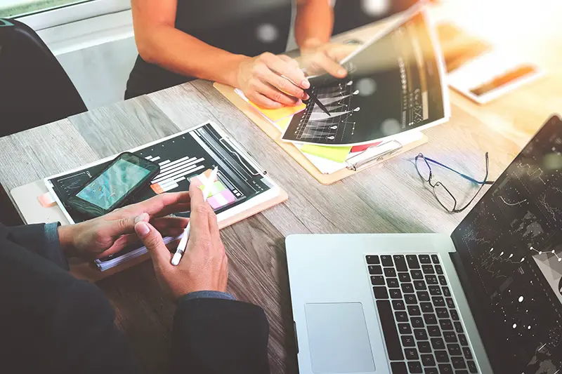 Two people at desk discussing digital marketing technigques for their small business.