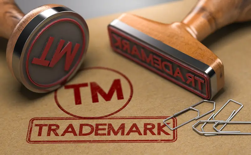 Trademark and TM stamped onto brown paper using Trademark and TM rubber stamps