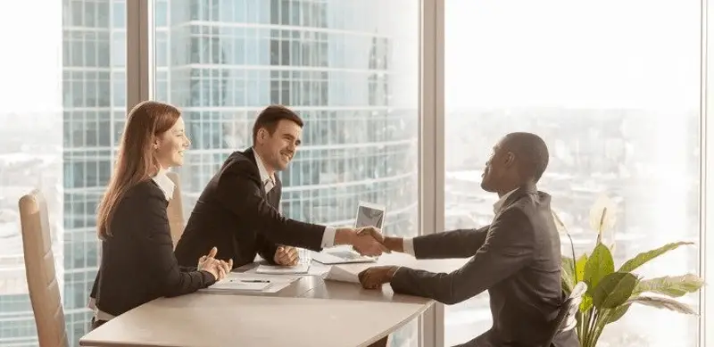 People shaking hands at in an office - enterprise customer support