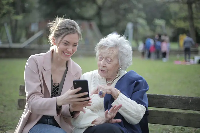 Senior mother and adult daughter using smartphone together