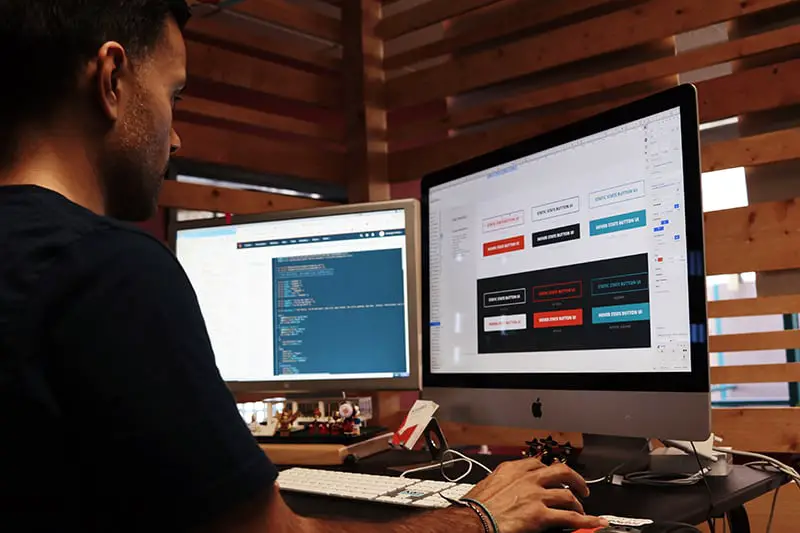 A man wearing black shirt working on his computer