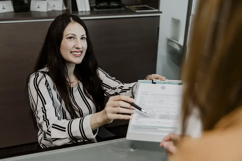 Happy woman handing the contract to the customer