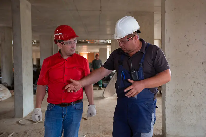 Two men wearing helmet in construction site