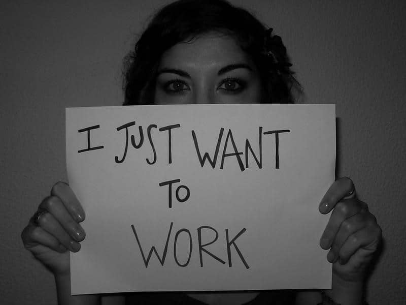 A black and white image of a woman holding a paper with text