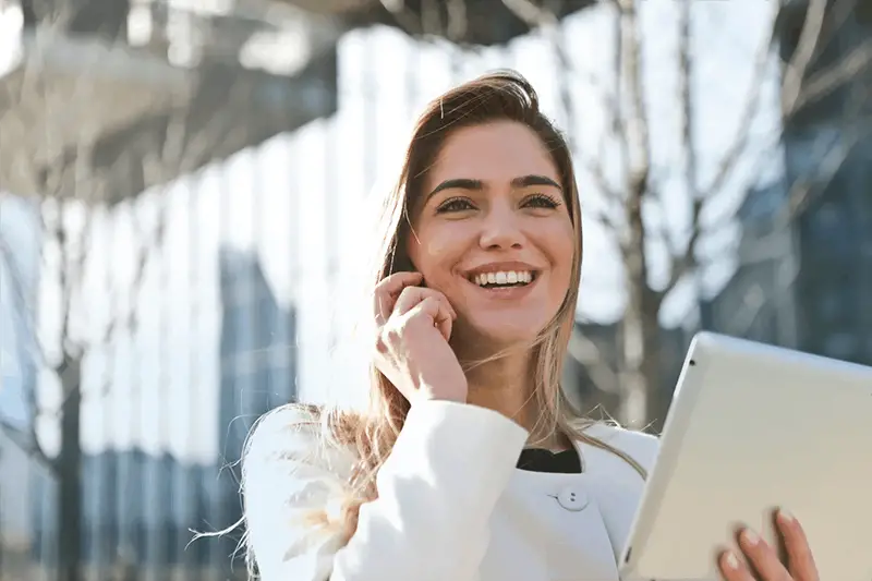 A smiling woman while talking  on her mobile phone