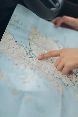 A hand of a person pointing on the map