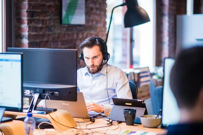 selective focus image of a man in wearing a shirt working in an office on IT project on laptop