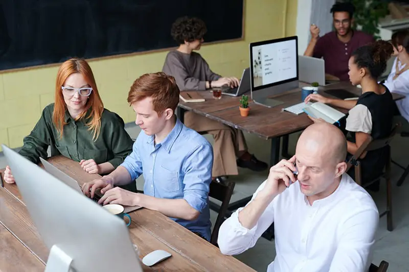 A group of people working in front of their laptop while chatting