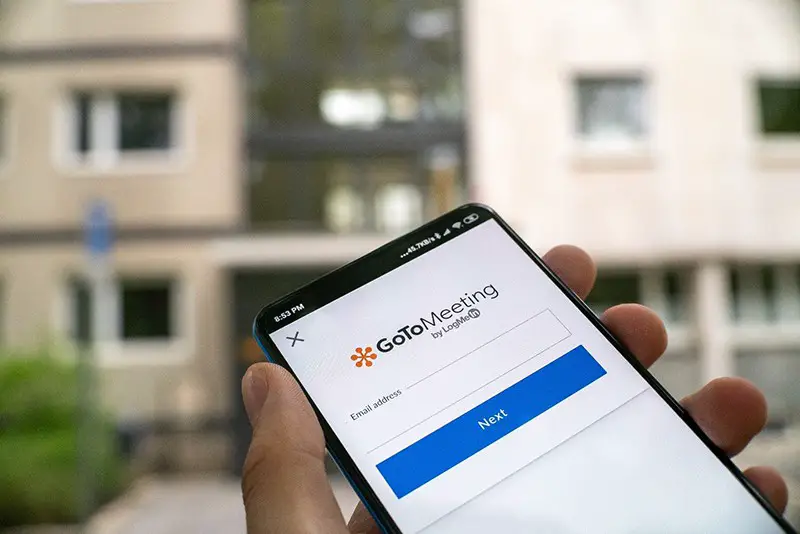 person holding smartphone with Gotomeeting app on the screen