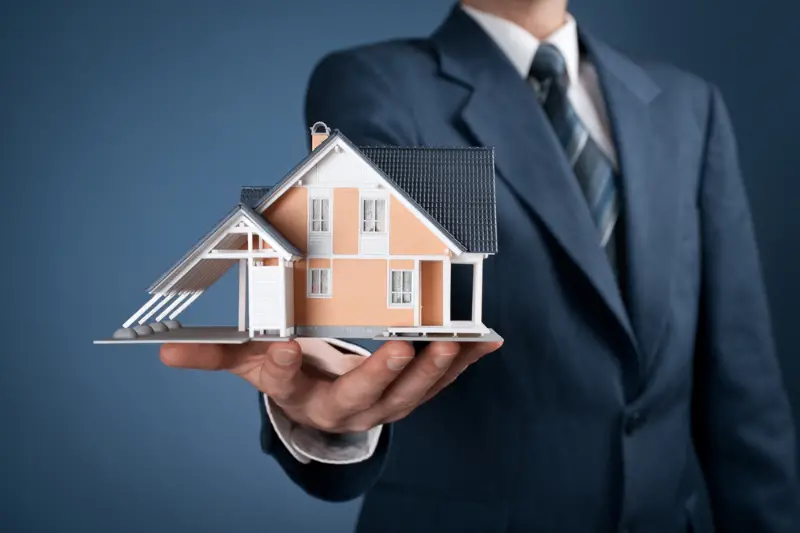 real estate agent holding house model