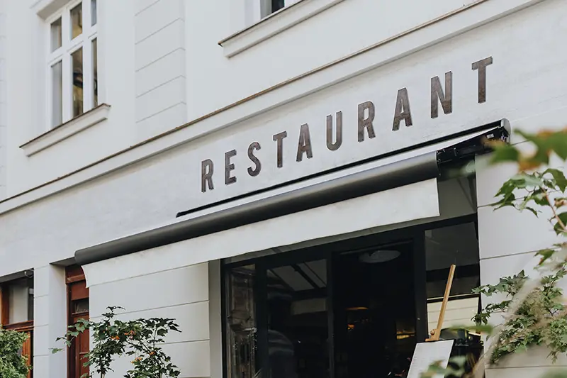 Restaurant sign on a white building.