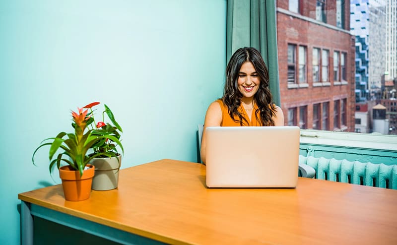 woman sat at a table using laptop