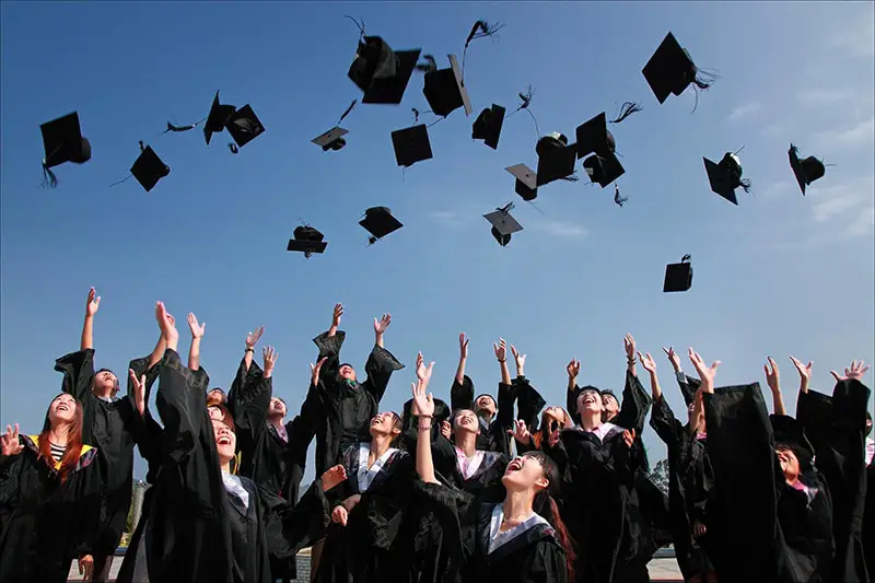 Newly graduated people wearing black academy gown