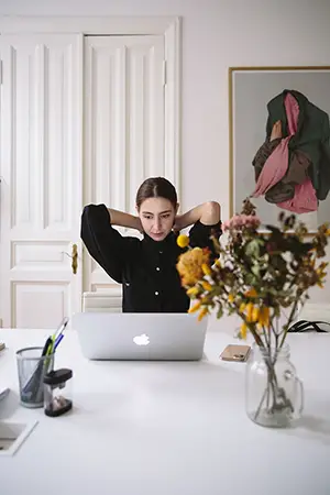 Woman wearing black in front mac pro laptop