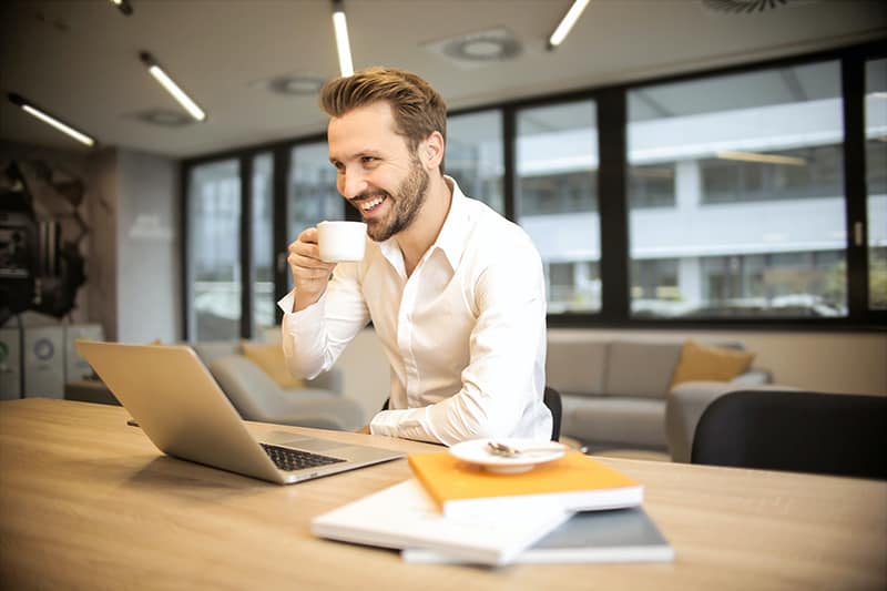 Man sitting on chair while holding a cup of coffee