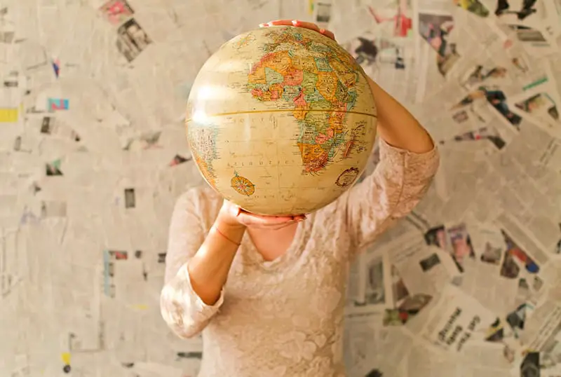 woman wearing lace dress holding desk globe