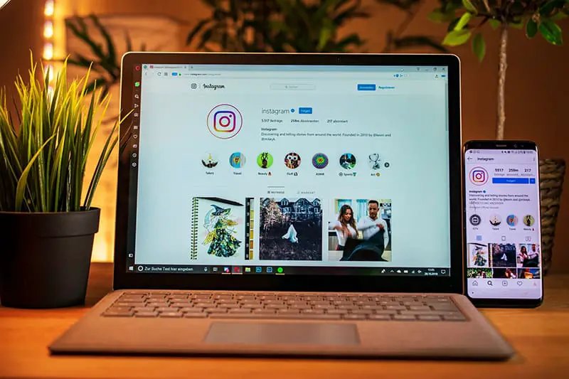 laptop and smartphone with instagram account on the screen