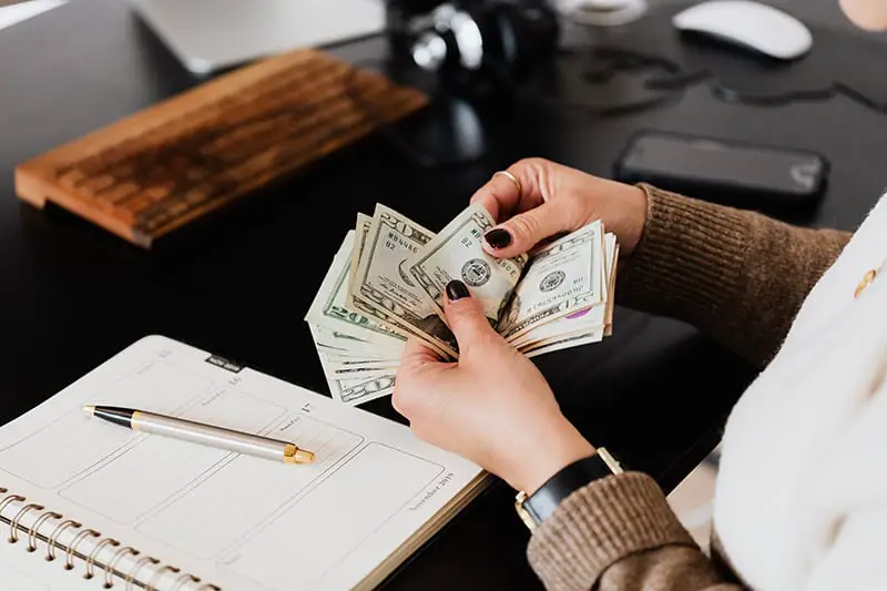 Woman counting money at the office table