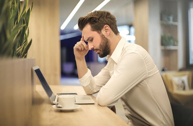 A stressed man in front of his laptop