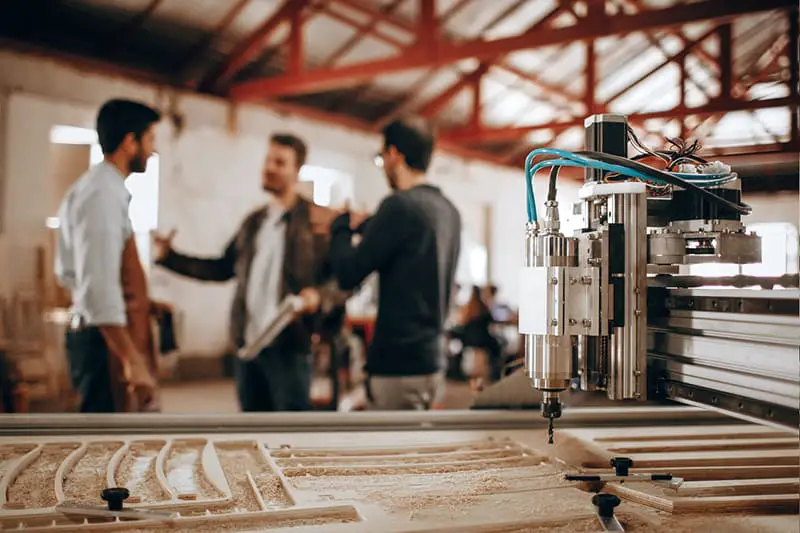 machinery in the foreground – men having a discussion in the background about furniture design and planning