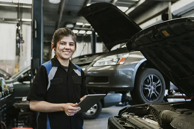 Woman mechanic running a diagnostic on a vehicle