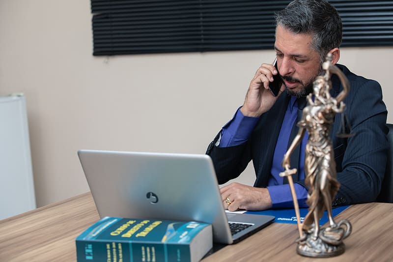 A lawyer on call while working on his gray laptop